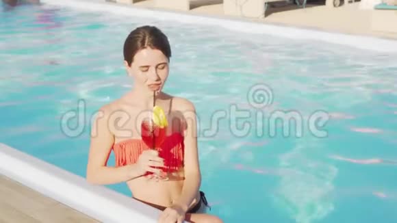在游泳池喝鸡尾酒的漂亮女人视频的预览图