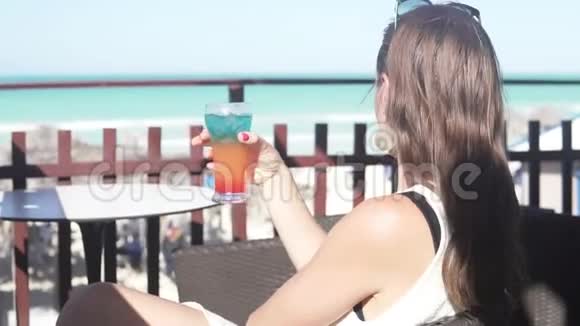 一个女人在海滩的酒吧喝鸡尾酒视频的预览图