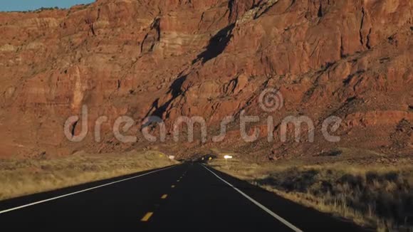 在沙漠的背景下在日落时分在岩石巨石的高墙上行驶视频的预览图