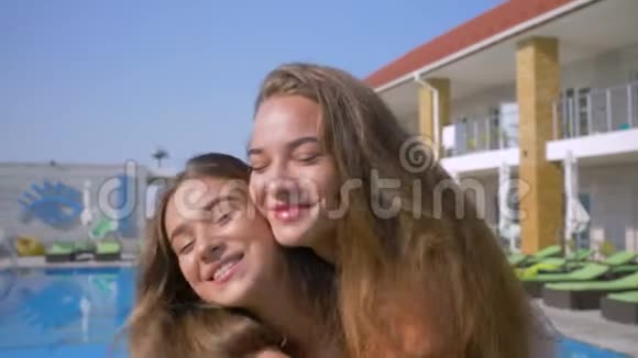快乐女朋友的肖像暑假期间在蓝池附近的美丽好友的情感拥抱视频的预览图