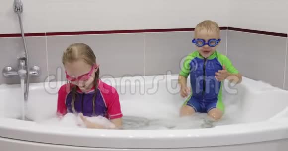 小男孩和一个姐姐在洗澡时玩得很开心视频的预览图