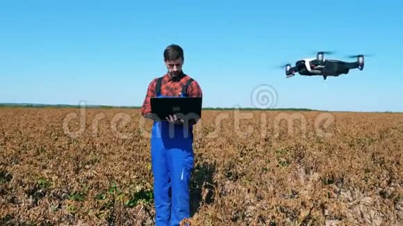 农业工人正在褪色的田野里驾驶无人机视频的预览图