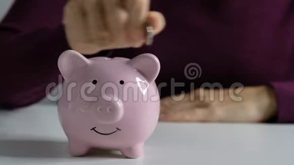 女人的手把硬币放在储蓄罐上储蓄经济概念视频的预览图