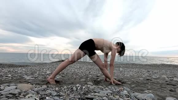 健身妇女伸展腿或在海滩上做午餐女运动员在海边做放松运动视频的预览图