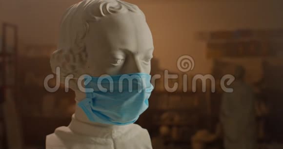 戴着医疗面具的旧古董白色大理石雕塑半身像的近景检疫方面的艺术概念雕塑家视频的预览图
