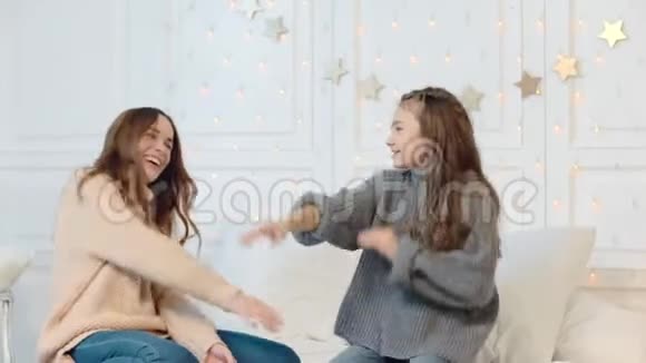 新年假期快乐的女孩和妈妈在床上跳舞视频的预览图