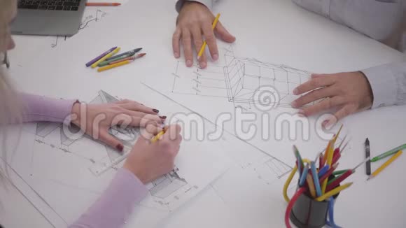 两位高加索建筑师在桌子上绘制蓝图的俯视图在办公室工作的男人和女人男性和女性视频的预览图