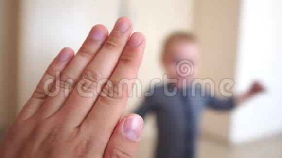 一个小男孩高兴地把五只手交给一个成年人他的手慢慢地放在室内视频的预览图