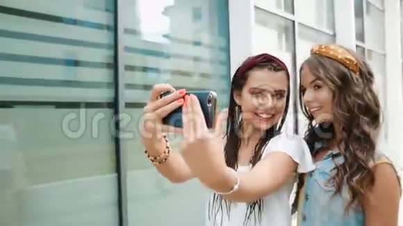 两个女朋友姐妹走在新大楼办公室附近城市拍照女孩们玩得开心散步笑跳带视频的预览图