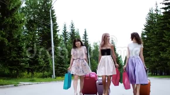 三个带着手提箱和购物袋的多民族女孩在度假时散步视频的预览图