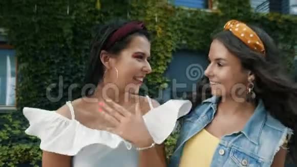 两个女朋友姐妹在城里相遇姐妹们玩得开心玩得开心女孩们在摆姿势笑漂亮时髦视频的预览图