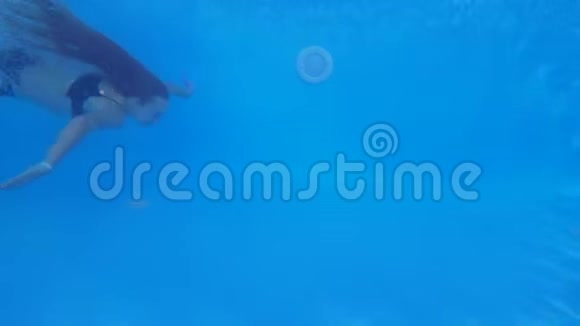 游泳池潜水长发年轻女性穿上泳装在清澈的蓝色泳池边漂浮在夏季假期视频的预览图