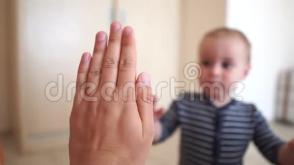 一个小孩在室内缓慢地向成人伸出五只的手视频的预览图