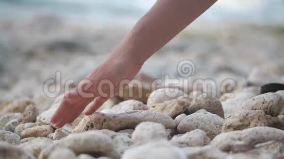 一个女人把手放在海洋上的石头表面放松放松4k视频的预览图