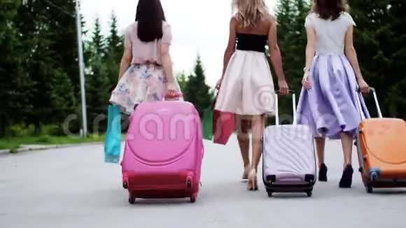 三个女人走着手提箱购物袋到了度假休息回头看视频的预览图