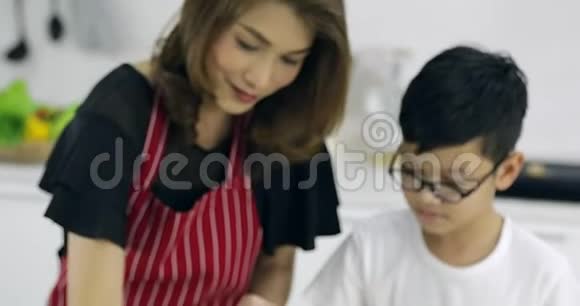 亚洲母亲和她的儿子一起在厨房做汉堡包视频的预览图