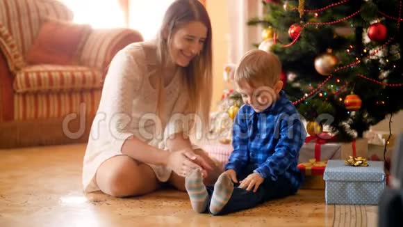 欢快的小男孩和妈妈一起扔彩色圣诞纸屑的视频一家人玩得很开心视频的预览图