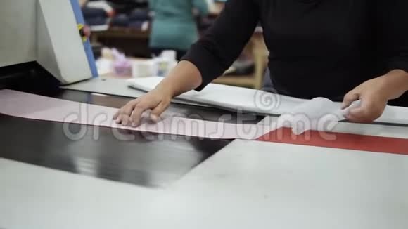 特写一段妇女手中不明的服装厂工人放置的纺织品织物图案视频的预览图