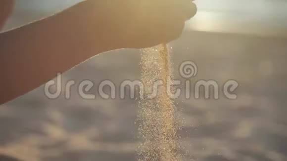 特写日落时分在热带海滩上女人的手在玩柔软的沙子背景是海水和海浪视频的预览图