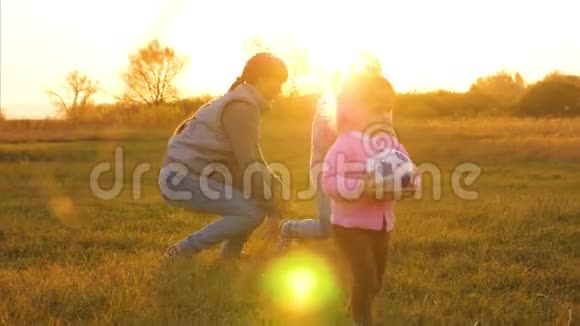 一家人在日落时孩子们在公园里打球妈妈和小女儿在舞会上玩慢慢视频的预览图