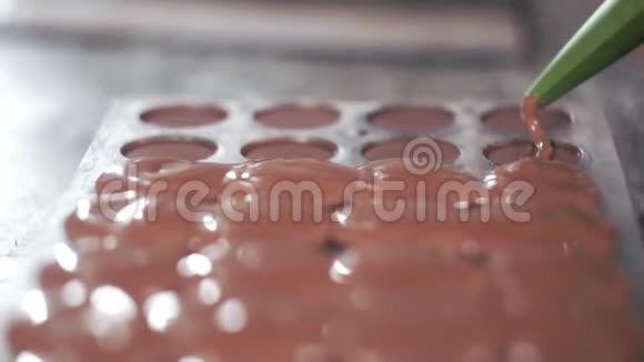 用管道袋中的黑巧克力填充聚碳酸酯邦邦模具视频的预览图