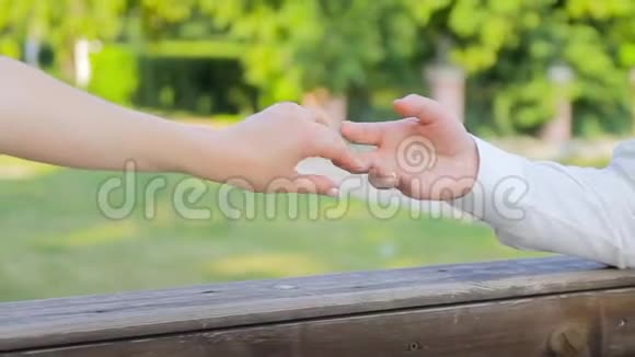 加入2只手作为爱和忠诚的象征夏天在背景中树木的叶子视频的预览图