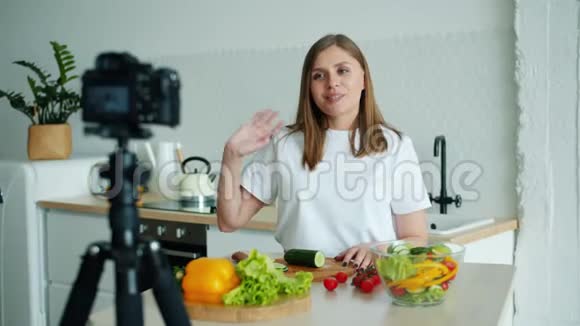 有魅力的女孩vlogger在厨房录制视频展示蔬菜烹饪视频的预览图