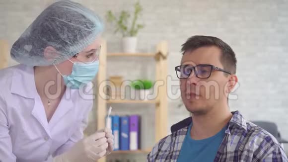 女实验室技术员用棉签从男人嘴里取唾液视频的预览图