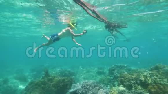 浮潜少女正在手机上拍摄海洋生物的照片水下拍摄视频的预览图