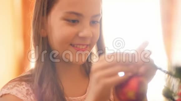 4k特写照片快乐微笑的少女挂在圣诞树华丽的球和饰品家庭装饰视频的预览图