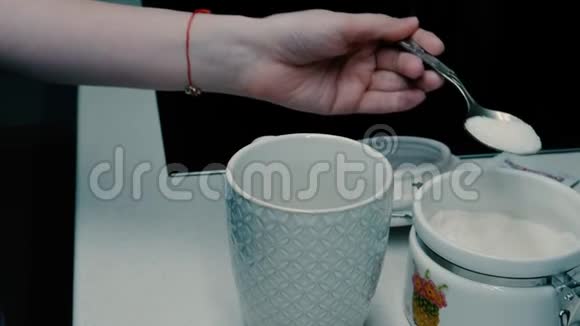 女孩把糖倒进玻璃杯里视频的预览图
