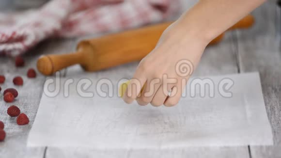 女用手用擀面杖在羊皮纸上擀面视频的预览图