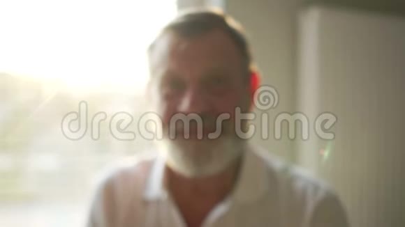 一位年长的快乐养老金领取者的肖像戴着灰色胡须和白色T恤的眼镜快乐视频的预览图
