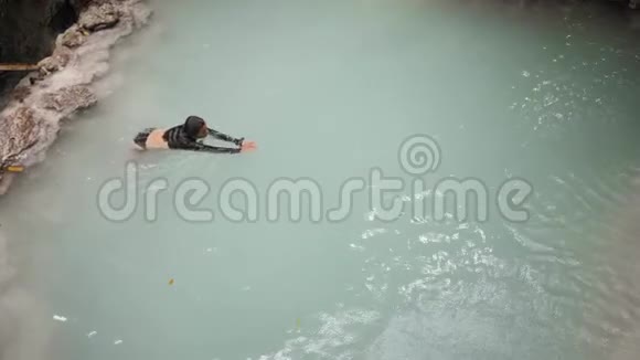 穿着泳装的苗条女人喜欢在瀑布流里游泳和洗澡视频的预览图