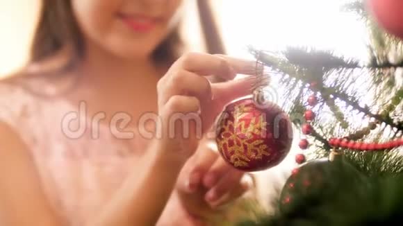 特写4k视频的年轻女子把红色的圣诞树树枝上的饰品家庭装修视频的预览图