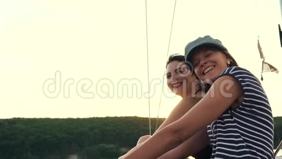 快乐的年轻女子享受日落河上的帆船之旅视频的预览图