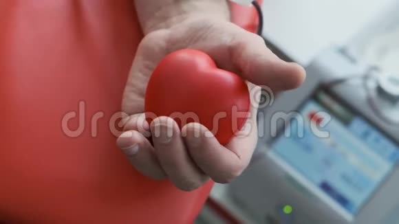 关闭手抓红色应力球献血程序输血站捐赠设备视频的预览图