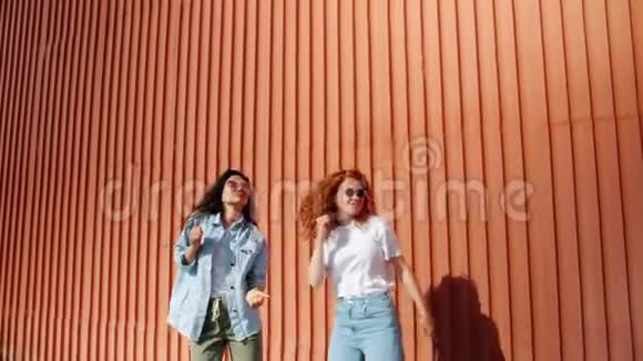 欢乐的亚洲和高加索女人在户外跳舞开心地笑视频的预览图