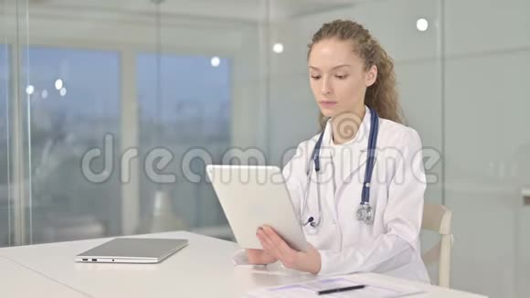年轻女医生在办公室的桌上做视频聊天视频的预览图