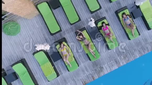 夏天在昂贵的度假胜地游泳池附近的躺椅上快乐的神奇女性朋友们穿着泳衣休息视频的预览图