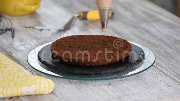 糖果女孩在巧克力海绵蛋糕上涂上巧克力奶油视频的预览图
