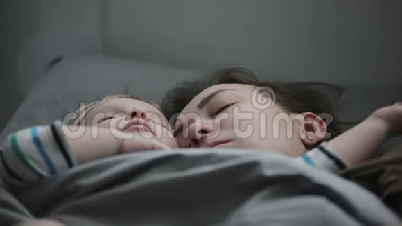 年轻母亲和婴儿在床上睡觉的特写TT视频的预览图