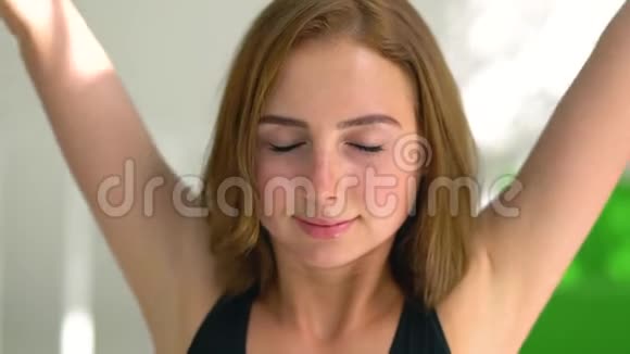 吸引人的集中高加索女人练习瑜伽做名字的肖像女孩慢慢地举起手来视频的预览图