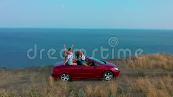 空中观景年轻女子在海边开敞篷车玩得很开心视频的预览图
