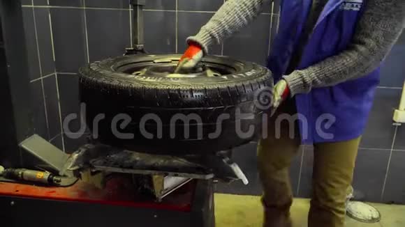 工人在汽车修理店里滚动轮子视频的预览图