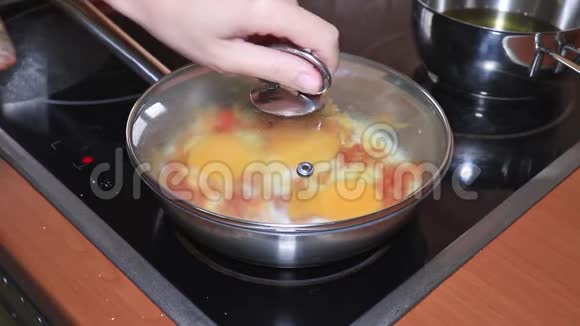 厨师做了一个煎蛋卷把鸡蛋放在一个平底锅里配上切碎的西红柿和洋葱然后用蔬菜做煎蛋卷视频的预览图