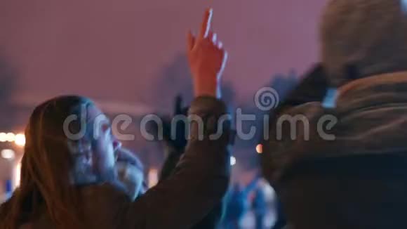 年轻人在城市广场的圣诞音乐会上聚会朋友们用挥动的双手跳起来用手跳舞视频的预览图