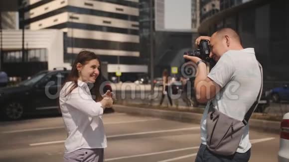 摄影师男在城市商业区拍摄一个女孩一些游客在中部地区视频的预览图