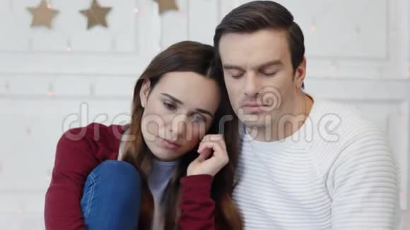 有想法的夫妇坐在客厅的画像伤心的女人躺在肩膀上视频的预览图