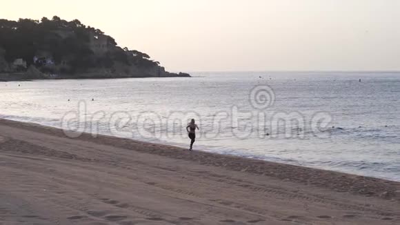 在海滩上快速奔跑时的适合女性的无人视野视频的预览图